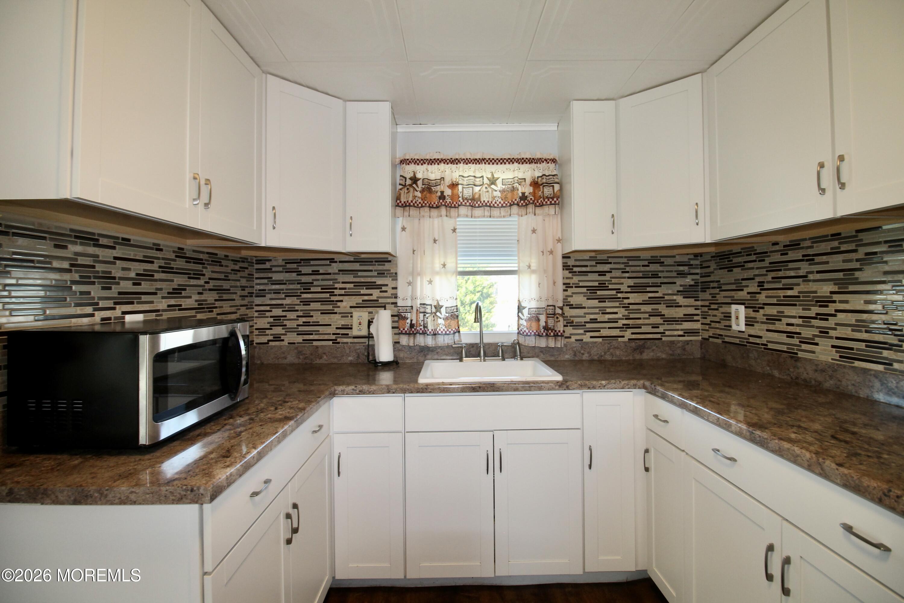 623 Sara Drive Freehold, NJ 07728 - Photo 10 of 28 a kitchen with granite countertop cabinets stainless steel appliances a sink and window