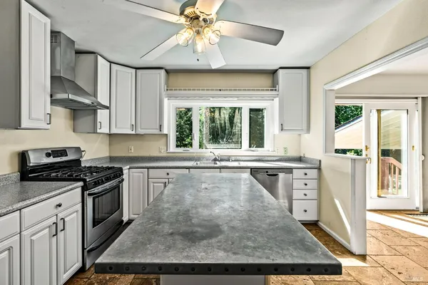 an empty room with wooden floor and ceiling fan