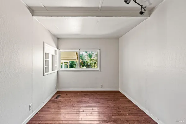 a view of a room with wooden floor and window
