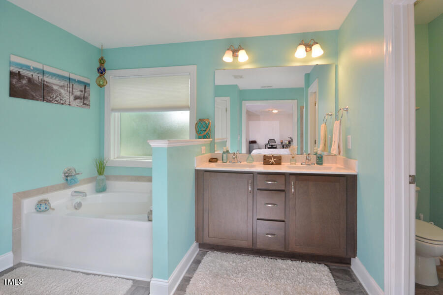 195 Timberwind Road Franklinton, NC 27525 - Photo 23 of 28 a bathroom with a tub a sink and mirror