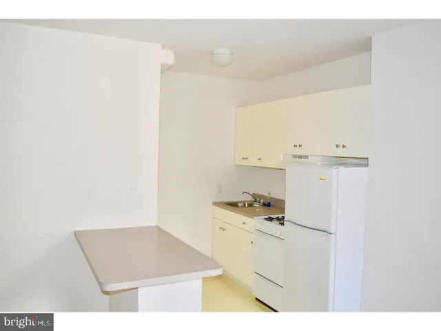a view of a kitchen with white cabinets