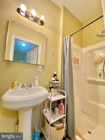 a bathroom with a sink a mirror and a shower