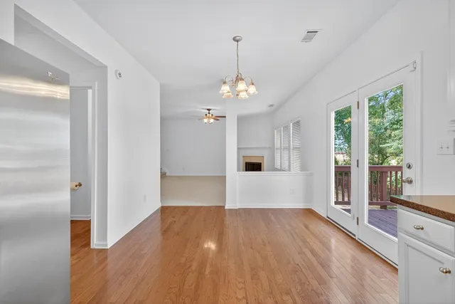 a view of a room with wooden floor kitchen view and a window
