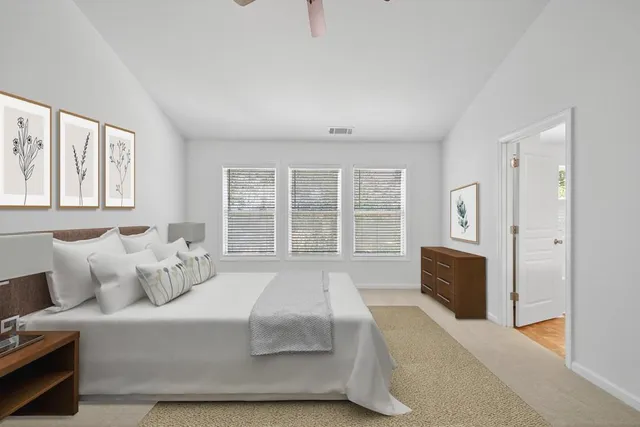 a spacious bedroom with a bed and glass window