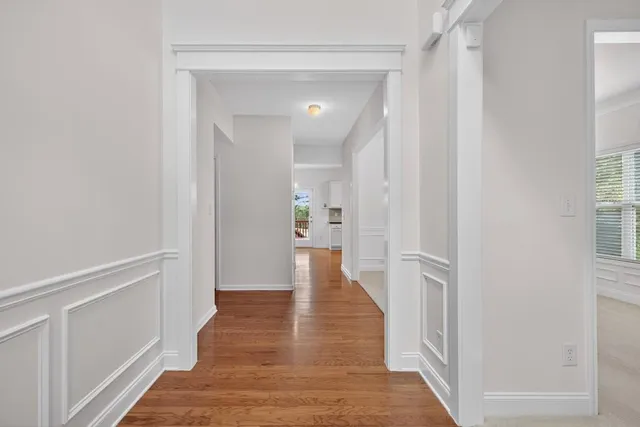 a view of a hallway with wooden floor and staircase