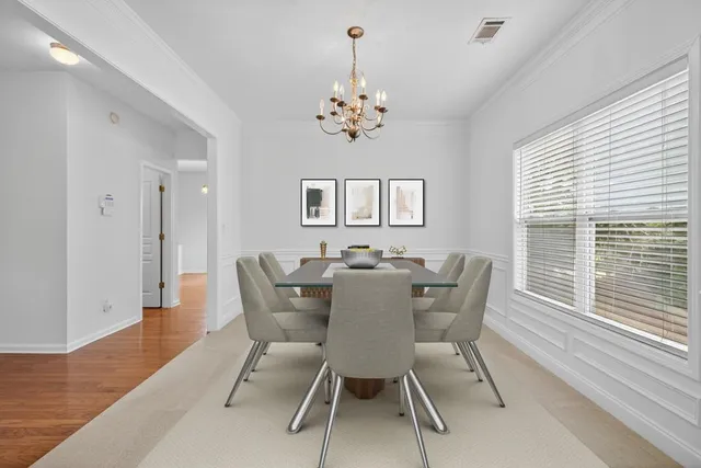 a view of a dining room with furniture a chandelier and wooden floor