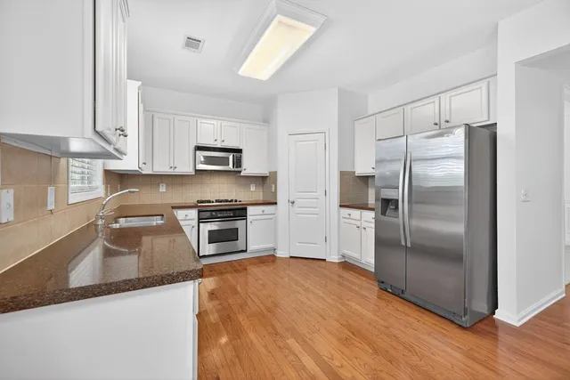 a kitchen with granite countertop a refrigerator and a sink