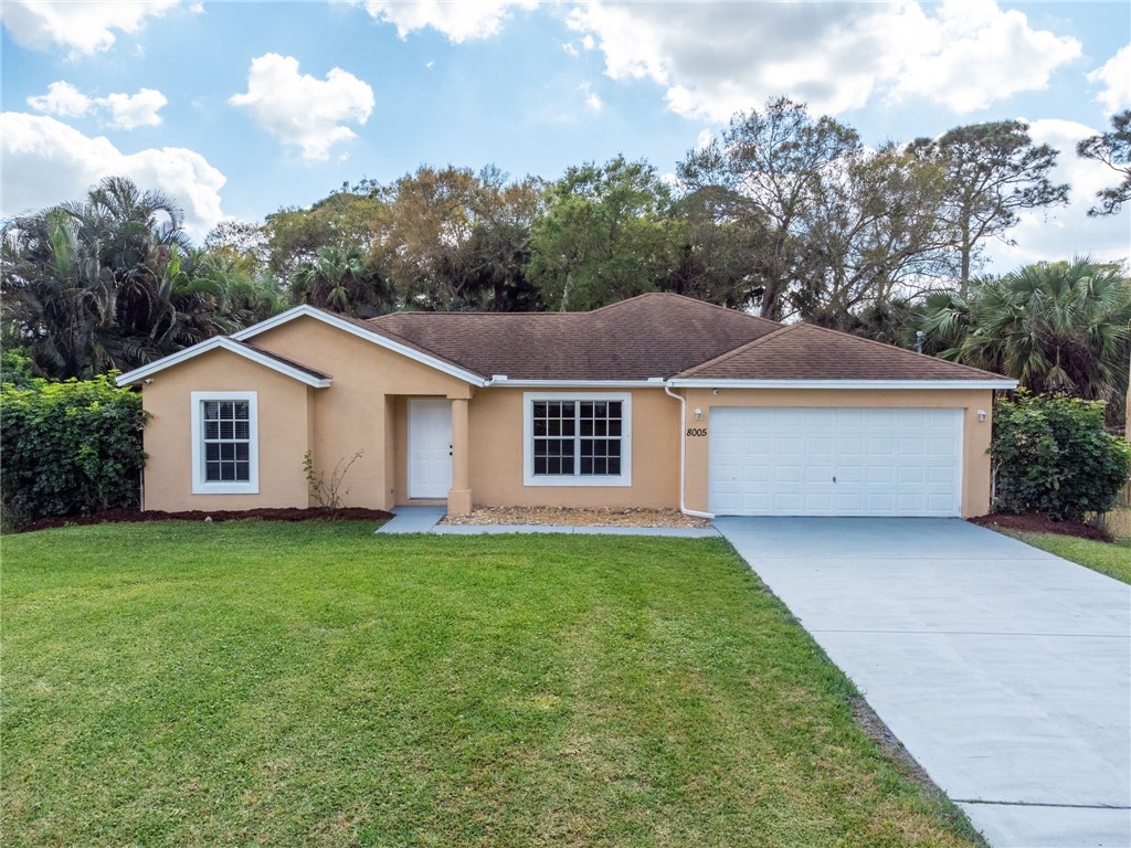 8005 Pensacola Road Fort Pierce, FL 34951 - Photo 1 of 36 a view of a yard in front of a house with plants and large trees