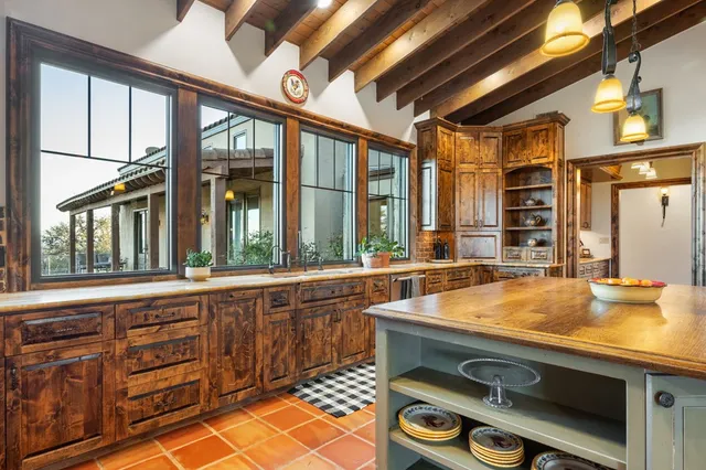 a hallway with wooden cabinets and stainless steel appliances