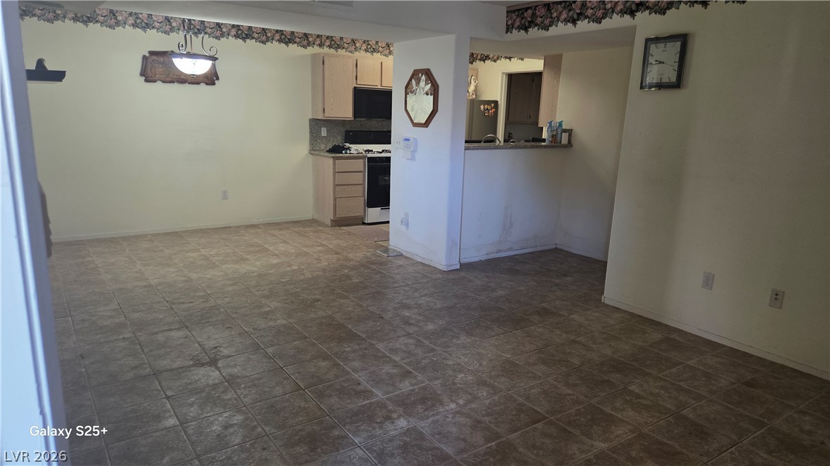 7885 West Flamingo Road, Unit 1008 Las Vegas, NV 89147 - Photo 14 of 29 Functional kitchen with ample cabinet space opens to an inviting living area.
