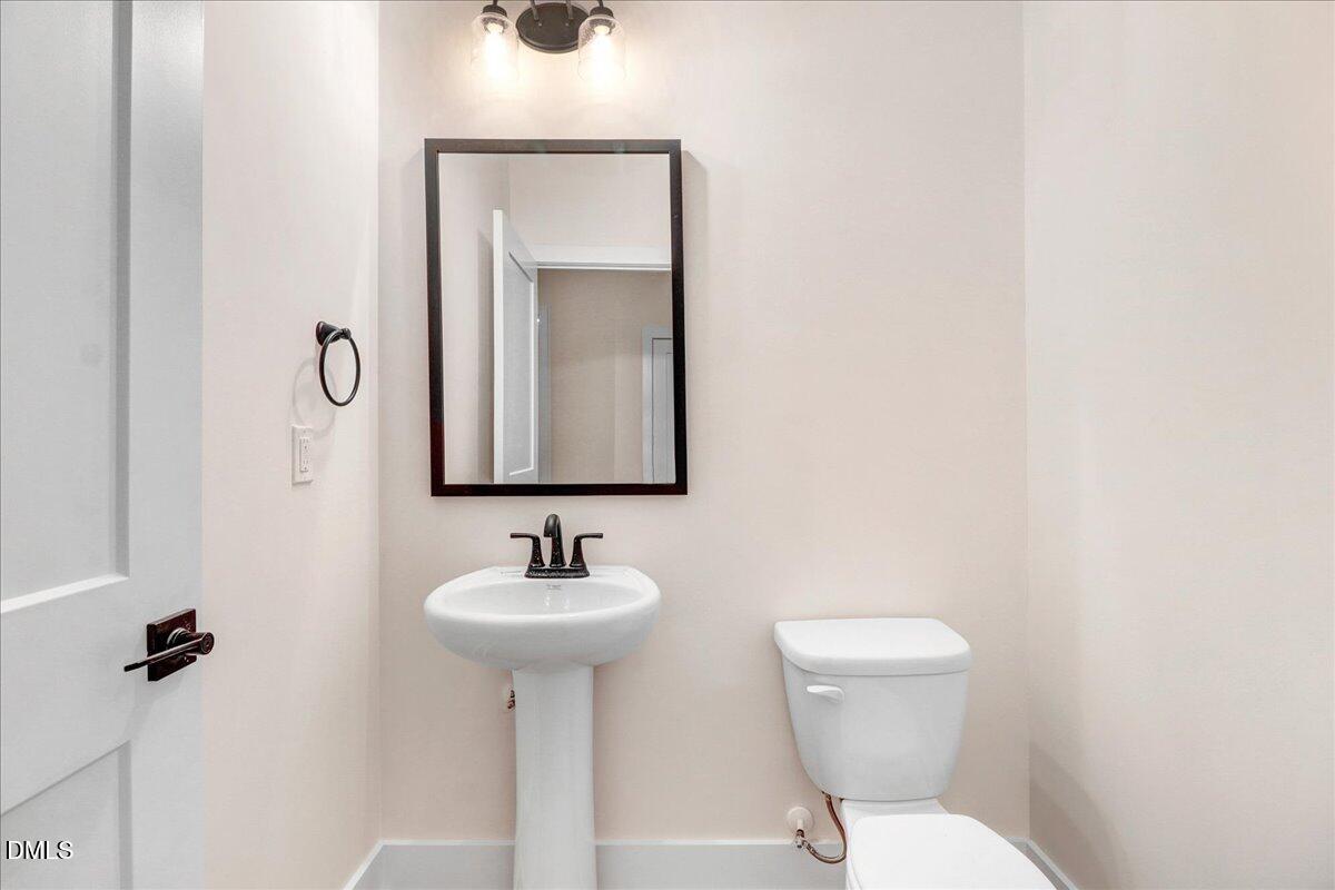 254 Galway Road Lillington, NC 27546 - Photo 17 of 35 a bathroom with a toilet sink and mirror