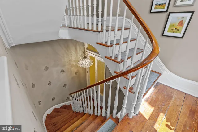 a view of staircase with wooden floor and white walls