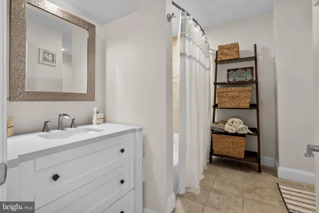 a en suite bathroom with a granite countertop sink and a mirror