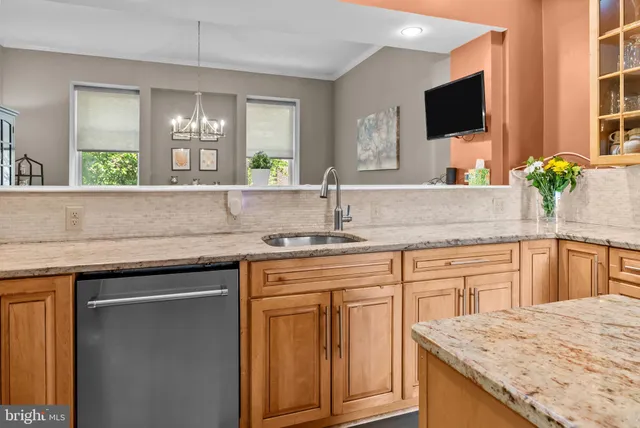 a kitchen with granite countertop a sink and a wooden floor
