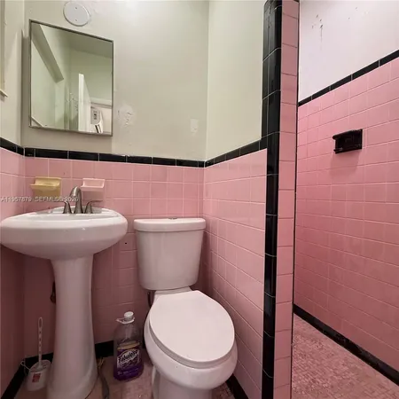a bathroom with a toilet sink and mirror