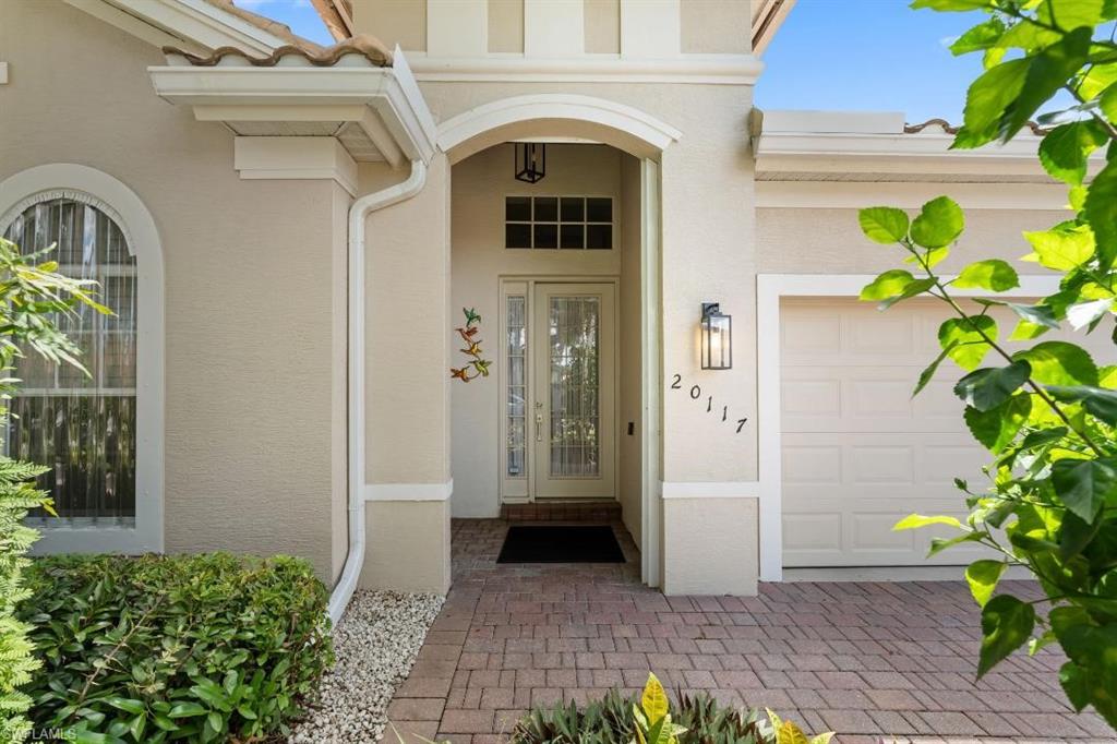 20117 Seadale Court Estero, FL 33928 - Photo 4 of 34 Arch-top entry with double doors, paver walkway, stucco exterior, and attached garage