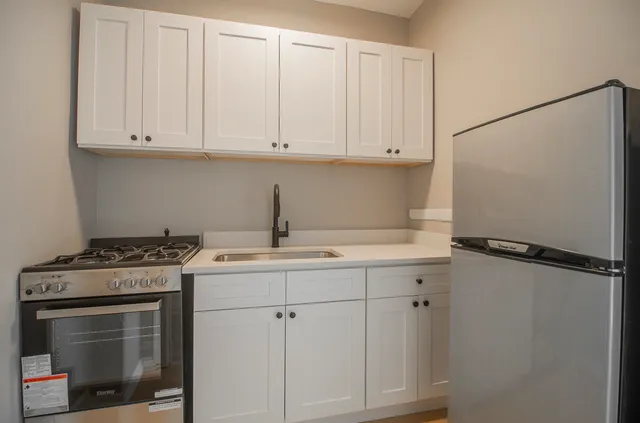 a kitchen with white cabinets and white appliances