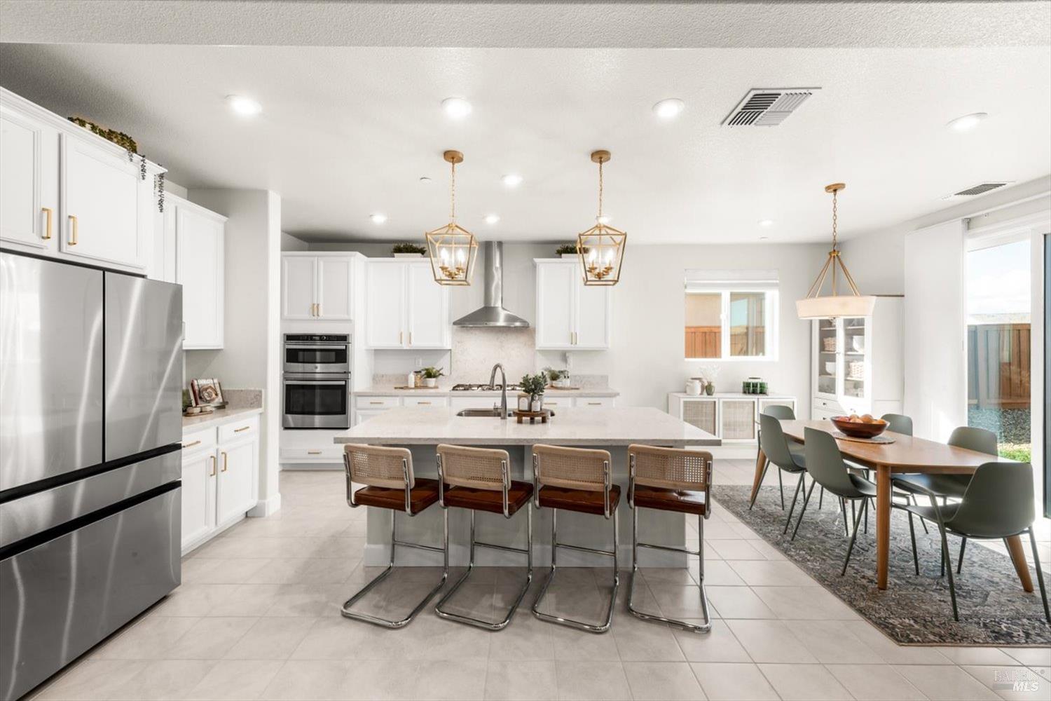 710 Fielding Way Dixon, CA 95620 - Photo 27 of 104 a kitchen with stainless steel appliances kitchen island granite countertop a dining table chairs and refrigerator