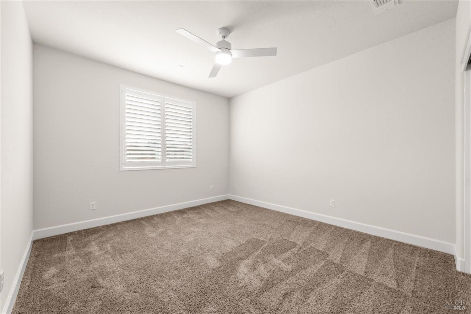 710 Fielding Way Dixon, CA 95620 - Photo 77 of 104 an empty room with a chandelier fan and windows