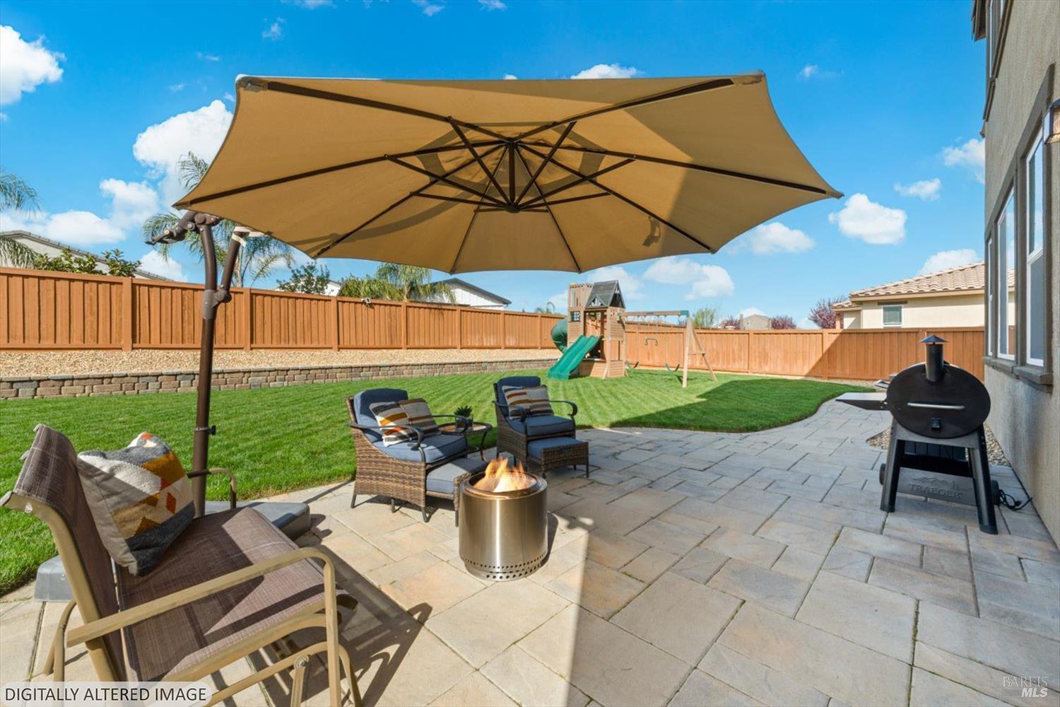 710 Fielding Way Dixon, CA 95620 - Photo 86 of 104 a patio with a table and chairs under an umbrella