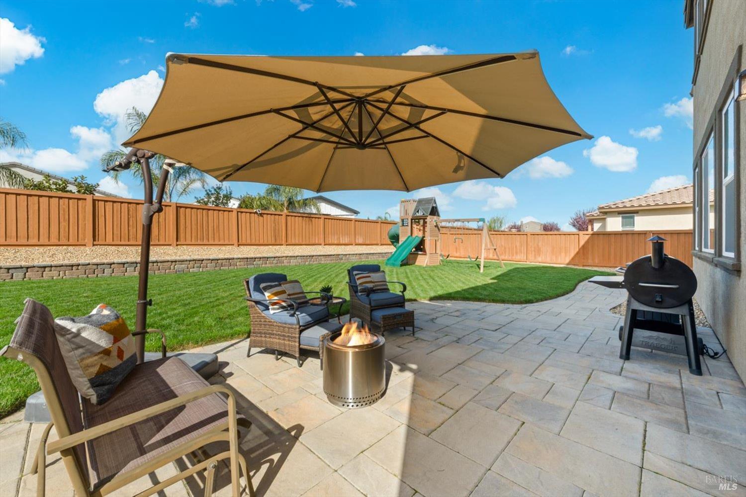710 Fielding Way Dixon, CA 95620 - Photo 89 of 104 a patio with a table and chairs under an umbrella