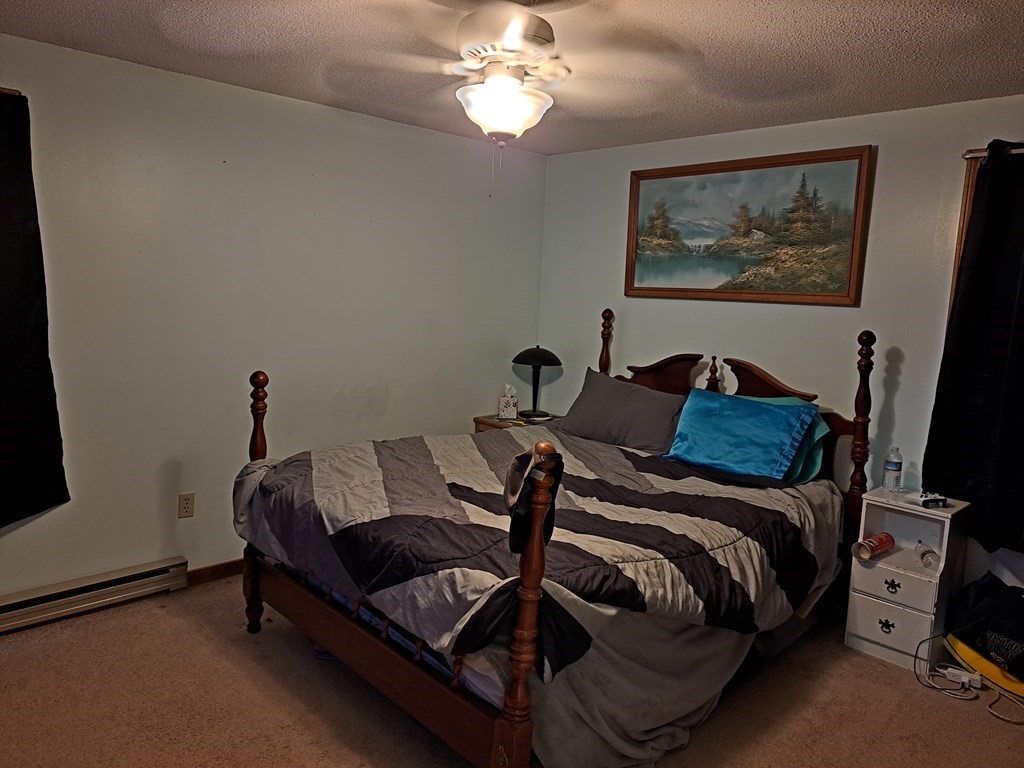 77 Collins Road New Ipswich, NH 03071 - Photo 13 of 26 a bedroom with a bed and a chandelier