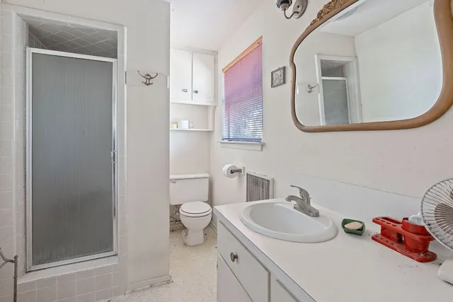 a bathroom with a sink vanity mirror and toilet