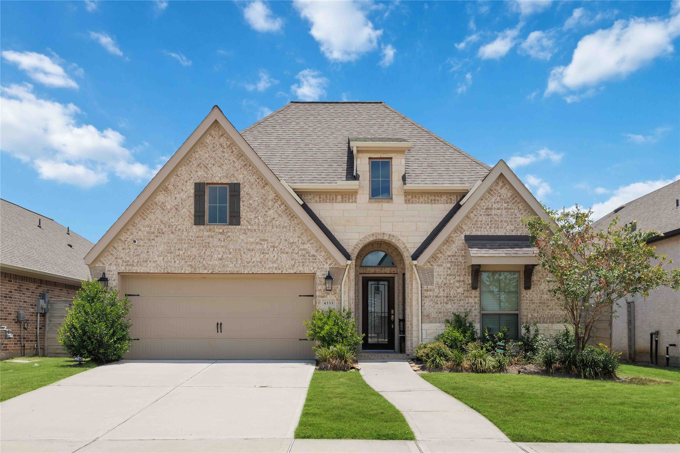 4333 Arbor Crest Lane Manvel, TX 77578 - Photo 1 of 40 Sharp rooflines and an elegant textures make up the exterior of this beautiful home, set against a flawlessly manicured green lawn.
