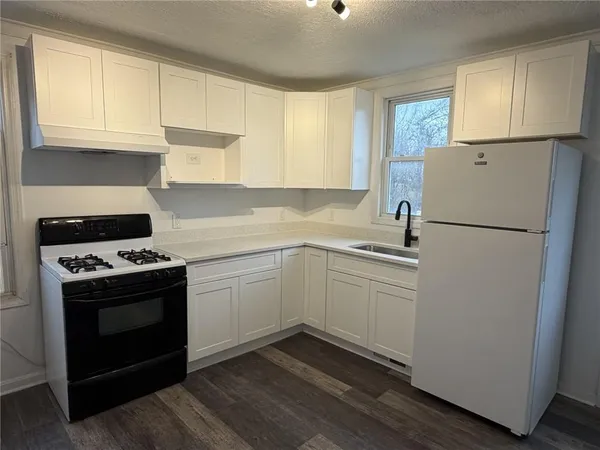 a kitchen with a stove top oven and refrigerator