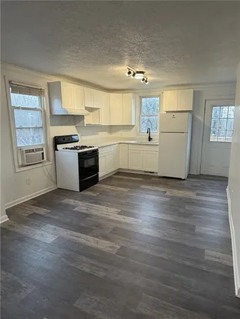 a view of a kitchen with wooden floor and electronic appliances