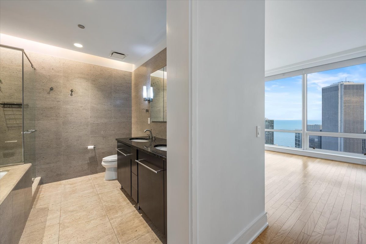 401 North Wabash Avenue, Unit 67F Chicago, IL 60611 - Photo 11 of 44 a bathroom with a double vanity sink toilet and shower