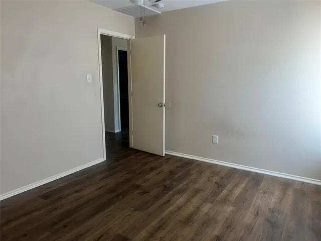 a view of a room with wooden floor and fan