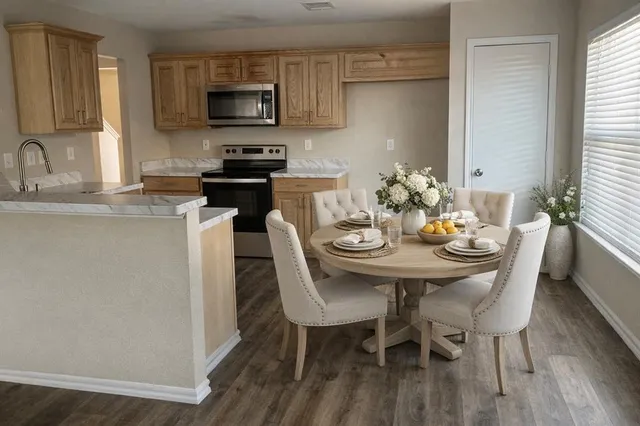 a kitchen with stainless steel appliances kitchen island granite countertop a sink a stove a microwave and dining table with wooden floor