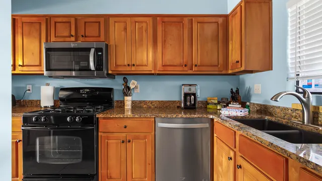 a kitchen with stainless steel appliances granite countertop a stove and a refrigerator