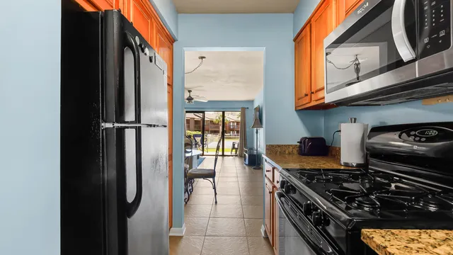 a kitchen with stainless steel appliances granite countertop a refrigerator a stove and a sink
