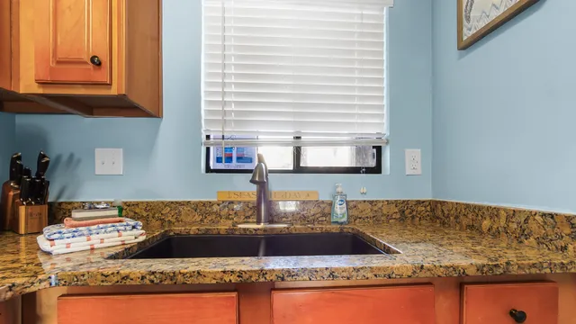a bathroom with a granite countertop sink and a mirror