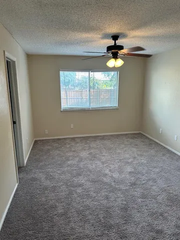 an empty room with a window and a chandelier