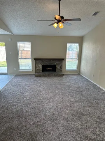 an empty room with a fireplace and chandelier
