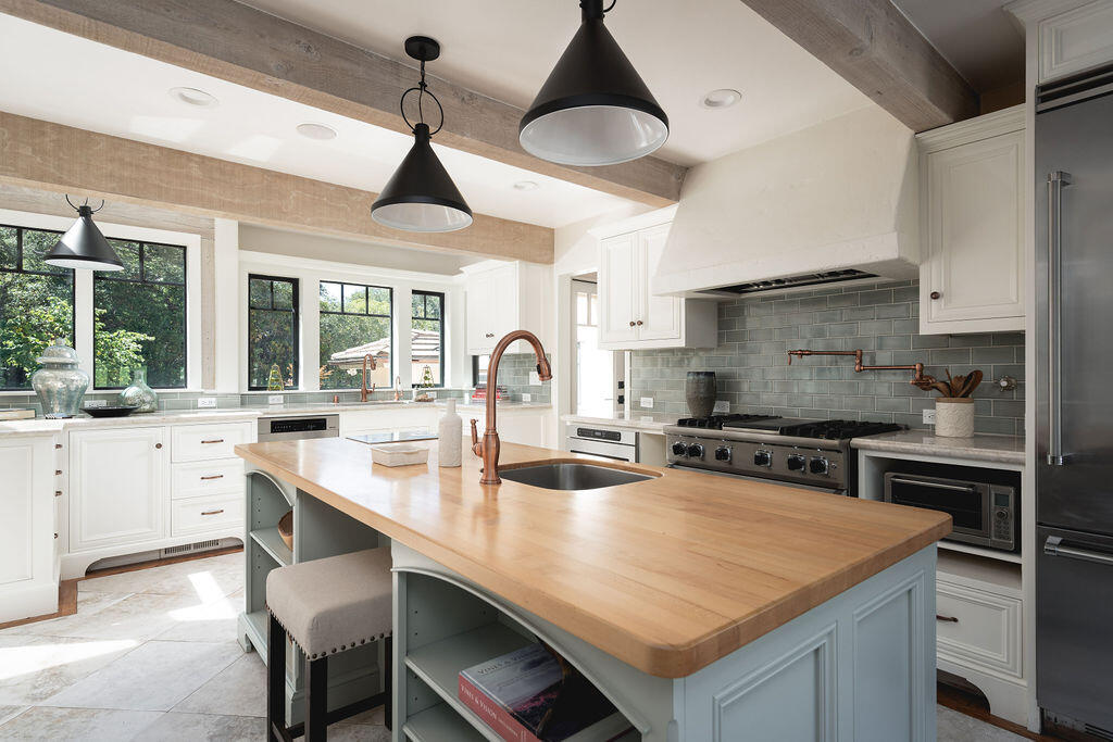 840 Ivy Lane Montecito, CA 93108 - Photo 30 of 57 a kitchen with a stove a sink a dining table and chairs