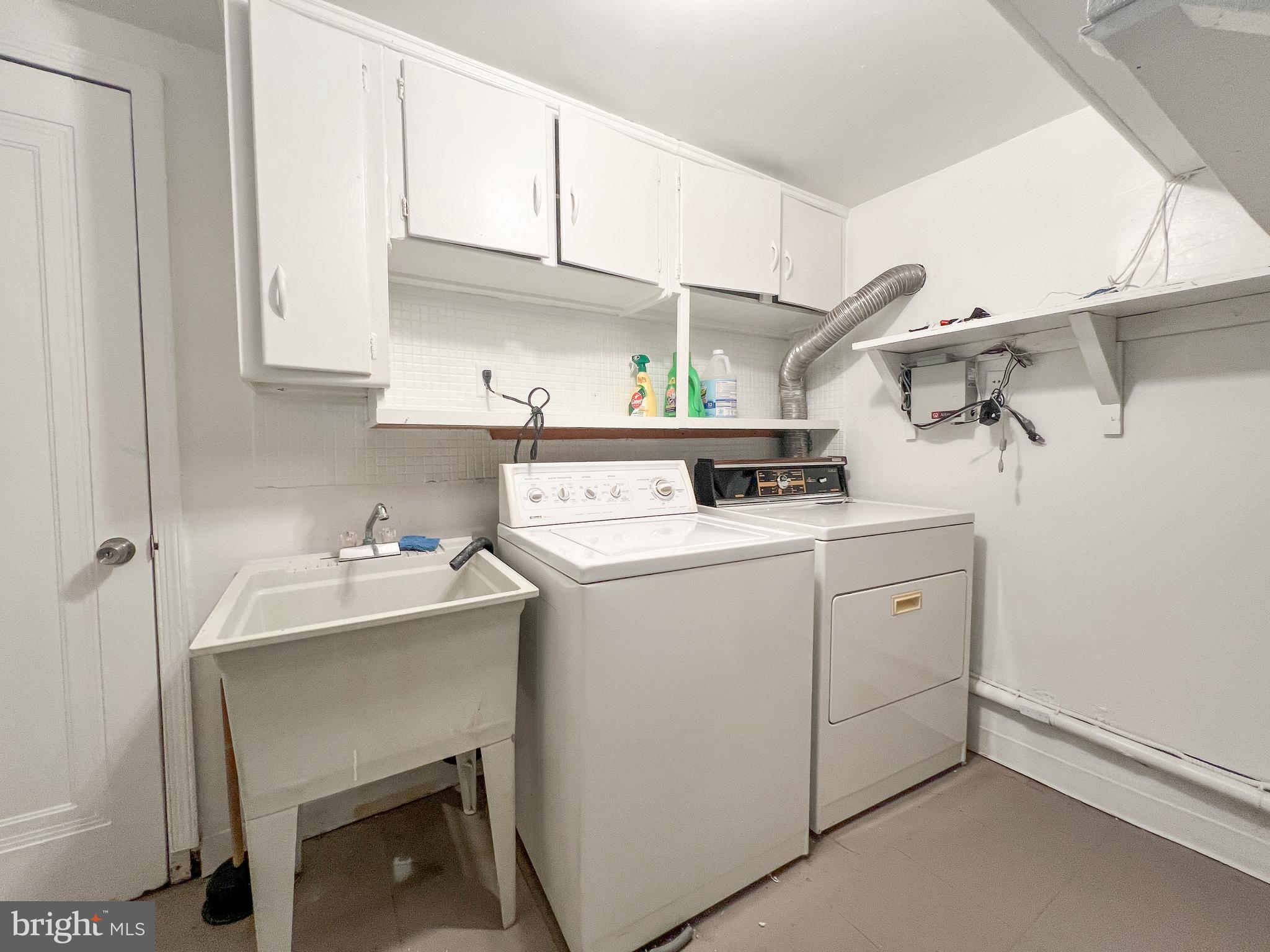 10209 Douglas Avenue Silver Spring, MD 20902 - Photo 19 of 22 a utility room with cabinets washer and dryer