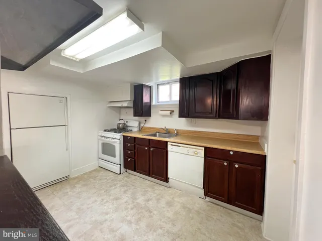 a kitchen with granite countertop wooden cabinets and white appliances
