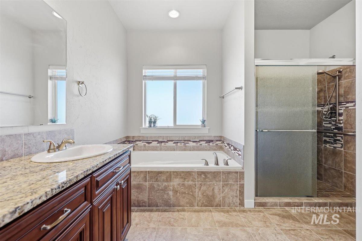 13496 Hockberger Ranch Road Caldwell, ID 83607 - Photo 25 of 40 Bathroom featuring a vanity with a granite countertop, an undermount sink, and dark wood cabinetry
