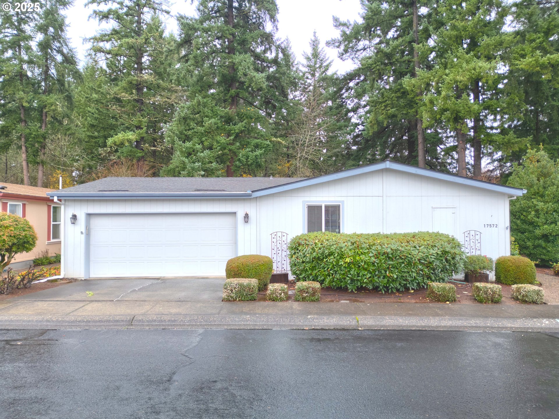 17572 Northwest Shady Fir Loop, Unit 24 Beaverton, OR 97006 - Photo 1 of 31 a front view of a house with a yard and garage