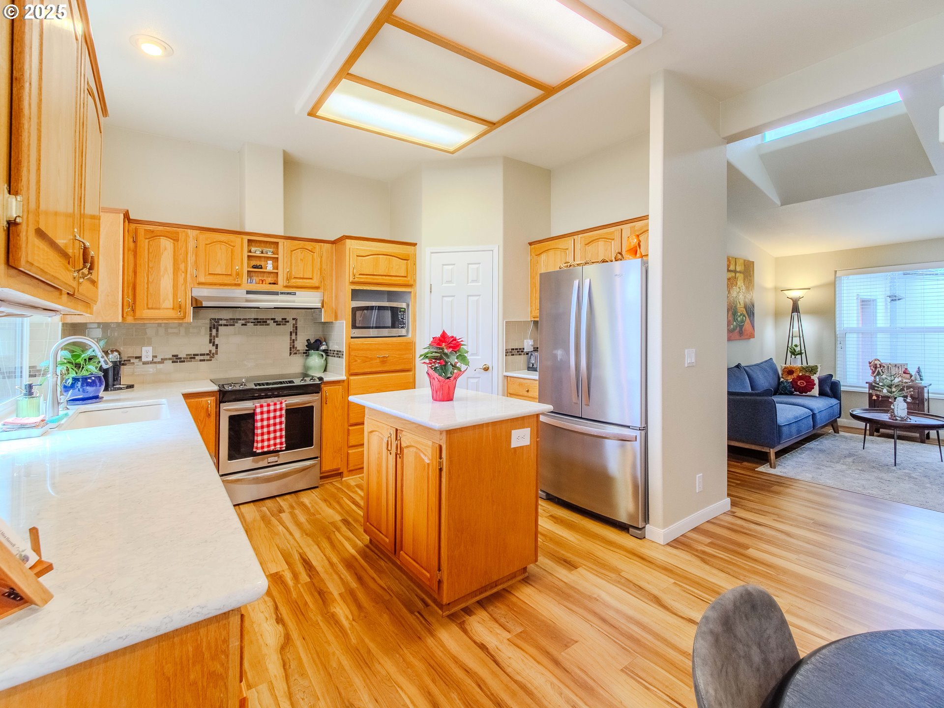 17572 Northwest Shady Fir Loop, Unit 24 Beaverton, OR 97006 - Photo 5 of 31 a kitchen with wooden floors and refrigerator