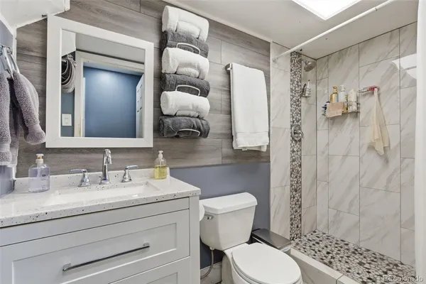 a bathroom with a sink a toilet and shower