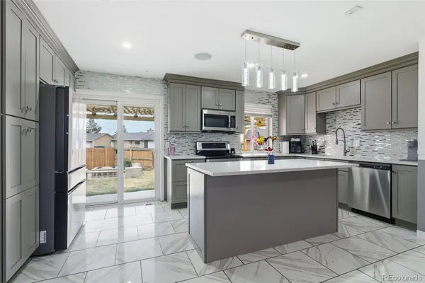 a kitchen with stainless steel appliances granite countertop a refrigerator and a stove top oven