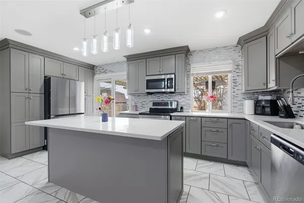 a kitchen with kitchen island granite countertop a sink stainless steel appliances and cabinets