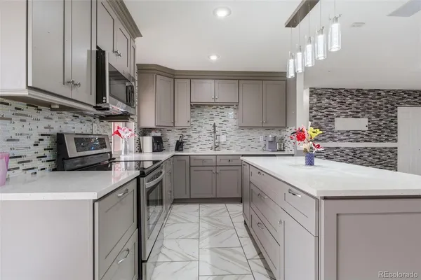 a kitchen with stainless steel appliances a sink dishwasher stove refrigerator and cabinets