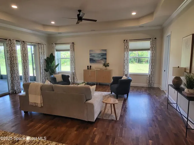 a living room with furniture wooden floor and a window