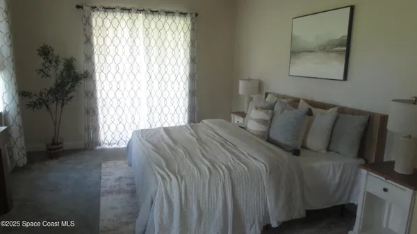 a bed sitting in a bedroom next to a window